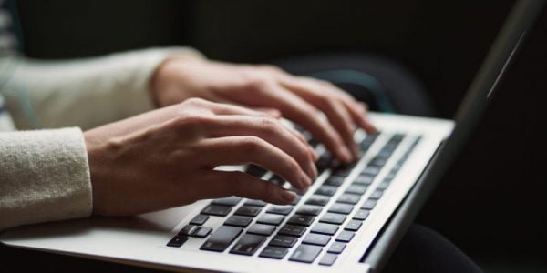 Woman's hands typing on laptop.