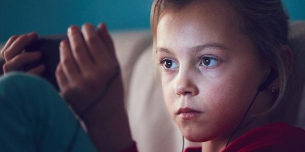 A girl using a smartphone and wearing earphones