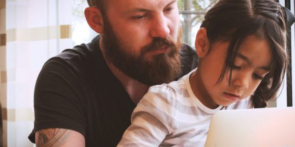 A child and an adult using a laptop together