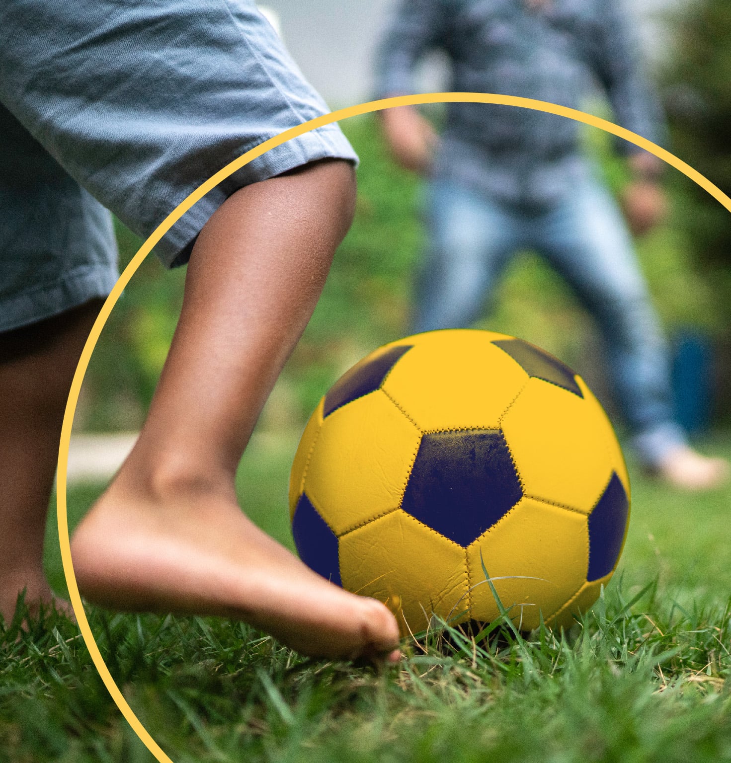 Child plays football barefoot