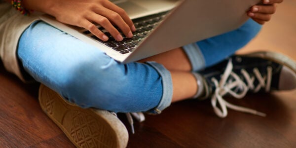 Close-up of laptop on crossed legs of girl.